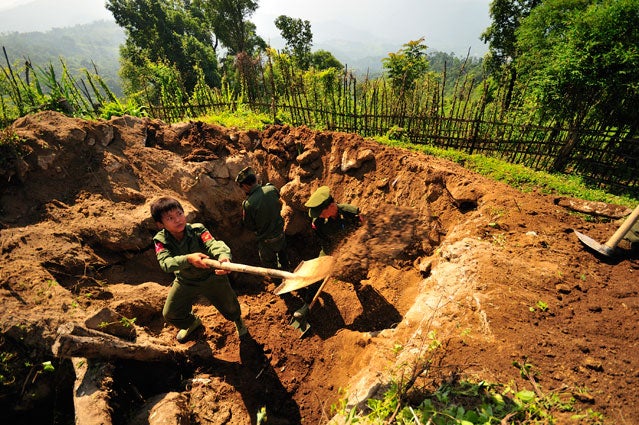 A 14 year old member of the KIA digging a bunker.