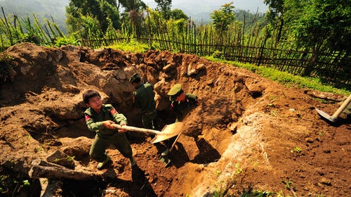 A 14 year old member of the KIA digging a bunker.