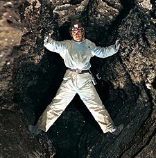 Ukrainian Speleological Association member Yevgeni Kislistim straddles a passage inside Ozernaja Cave, in Western Ukraine