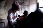 Dr. Lucy Doyle, a physician with Doctors Without Borders, examines a patient in a makeshift medical clinic in a building at the Ocean Village housing complex.