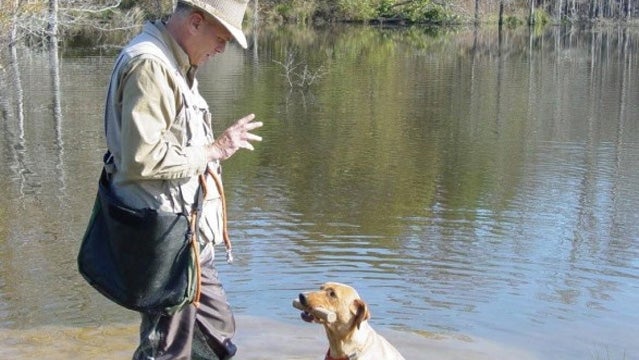 Mike Stewart holds the dog's eyes while the dog practices a hold.