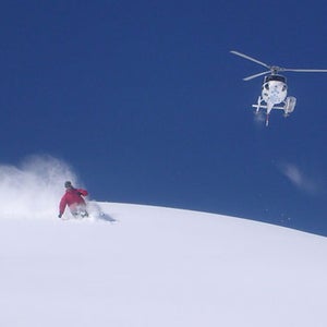 Skier with helicopter in background.