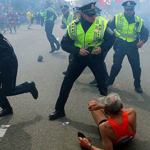 Police officers react to a second explosion at the finish line of the Boston Marathon in Boston, Monday, April 15, 2013. Two explosions shattered the euphoria of the Boston Marathon finish line on Monday, sending authorities out on the course to carry off the injured while the stragglers were rerouted away from the smoking site of the blasts. (AP Photo/The Boston Globe,  John Tlumacki)