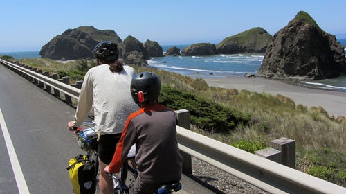 A family rides bikes down the California coast