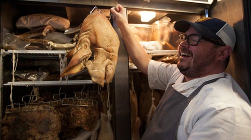 Sean Brock takes stock of a curing hog.