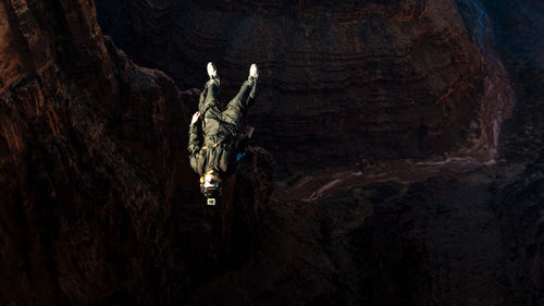 Base jumper Scotty Bob performs an aerial at the beginning of a jump while wearing a tracking suit. This suit inflates with air via several vents and increases the surface area of the jumper, allowing Bob to propel his body forward without the use of a dangerous and restrictive wingsuit.