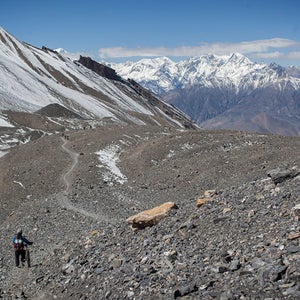 A group of mountain bikers rides along a narrow path towards the town of Muktinath and the historic Kali Gandaki Valley in Annapurna, Nepal (October 2013)