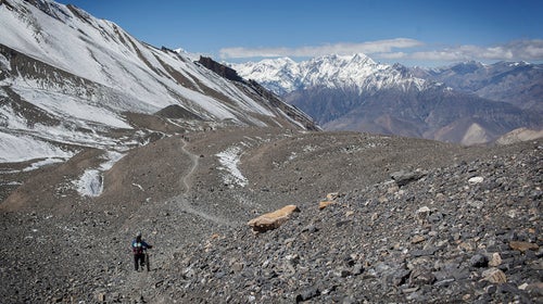 A group of mountain bikers rides along a narrow path towards the town of Muktinath and the historic Kali Gandaki Valley in Annapurna, Nepal (October 2013)