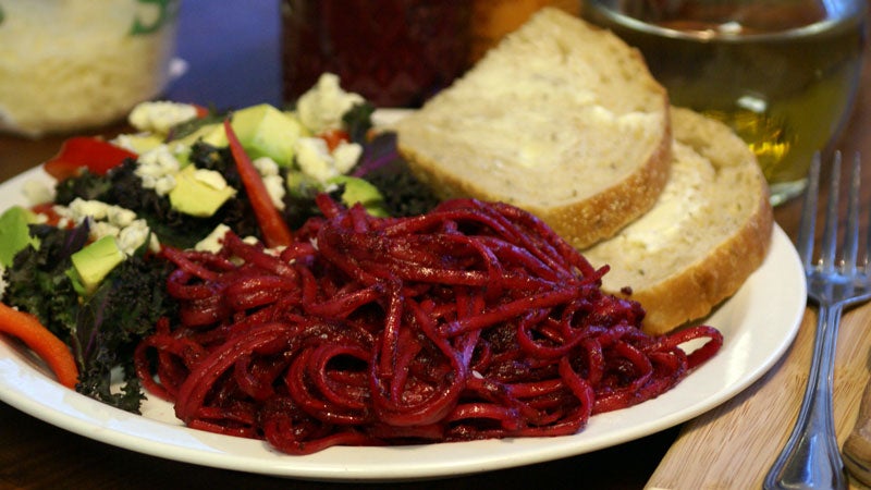 Beet Pesto; Linguine with beet pesto; a side kale salad with Gorgonzola cheese; avocados and red bell pepper; and some sliced artisan bread with butter.