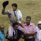 Frenchman Sebastian Castella waves to aficionados while riding triumphantly on the shoulders of a fellow bullfighter on the final day of Medellin's 2014 bullfighting season.