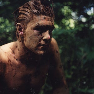 Learning by doing: a Tom Brown wanna-be prepares to stalk prey by muddying up his body to 