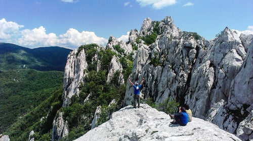 Our next Bosnian dispatch finds the writer in jagged territory. Perched atop Vranji Kuk in the range's central region, author Alex Crevar, seated on the right, and Bosnian mountain guide Lejla Terzić watch as Thierry Joubert, a mountaineer from Sarajevo, exalts in the untamed beauty.