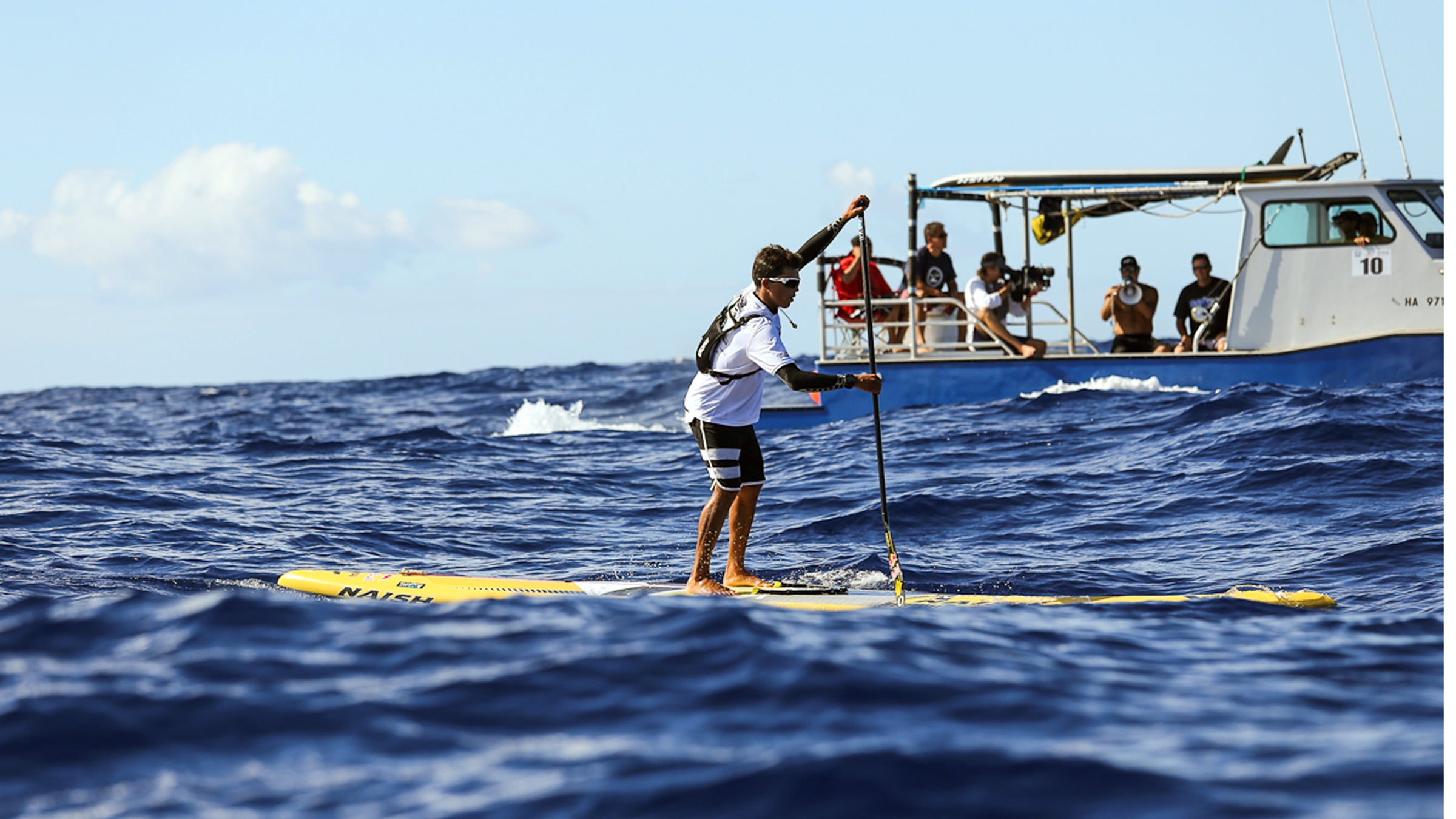 Kai Lenny takes to the board as Dave Kalama coaches from a boat with a megaphone. Is the new saying, "Keep your teammates close, and your competition closer?"