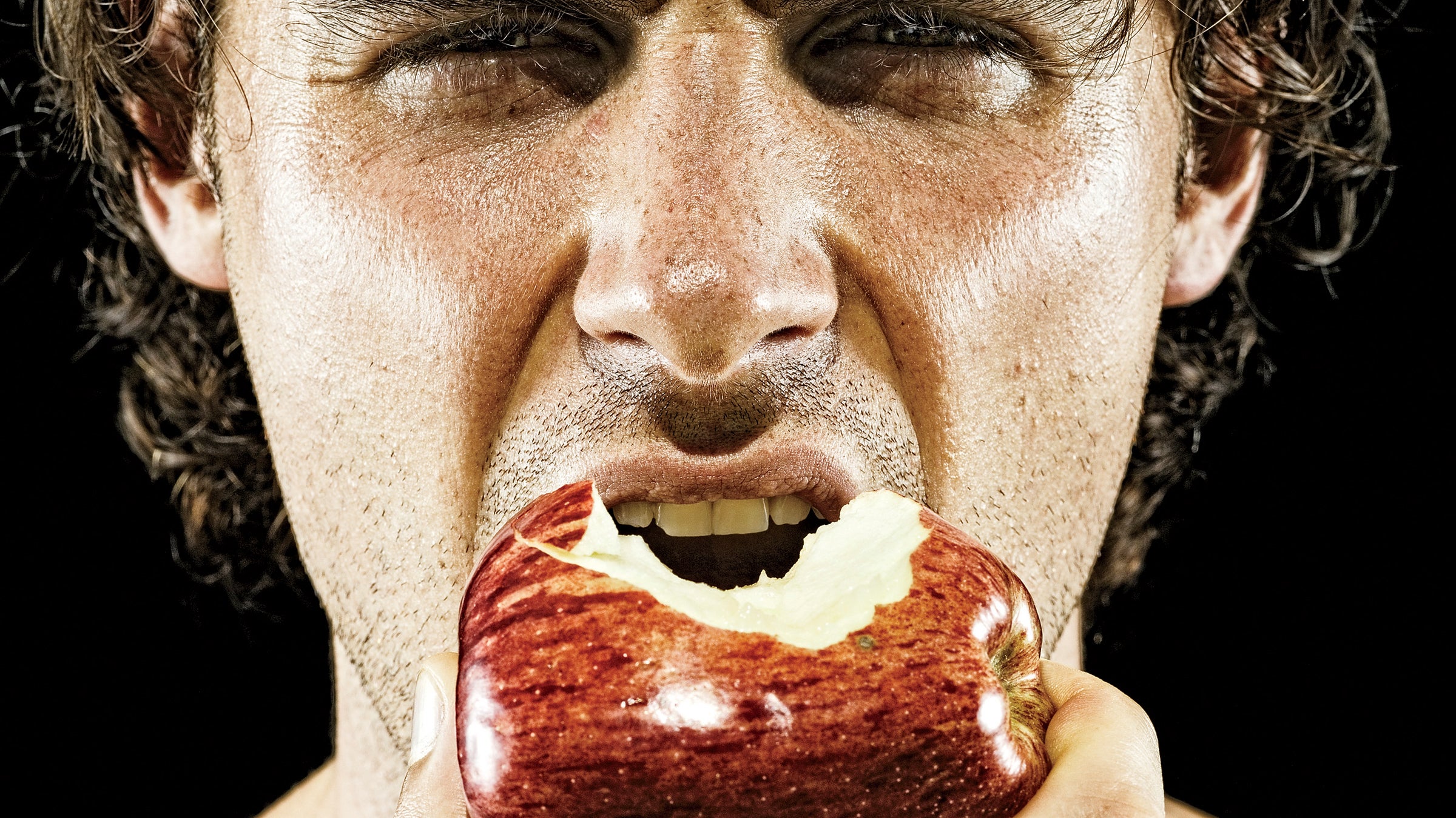 man biting into apple