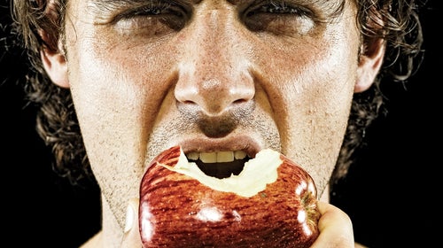 man biting into apple