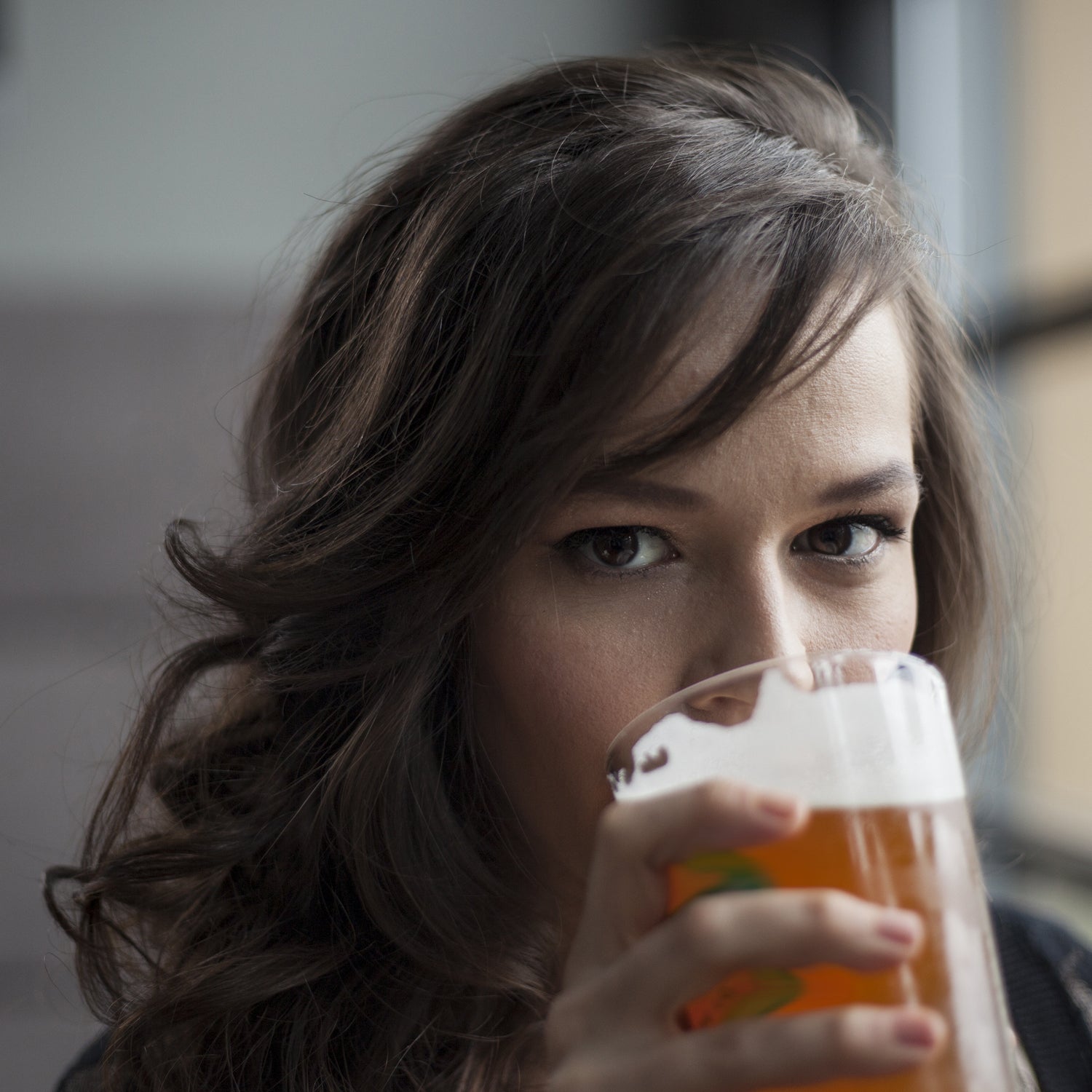 Young Woman Drinking a Pint Glass of Pale Ale