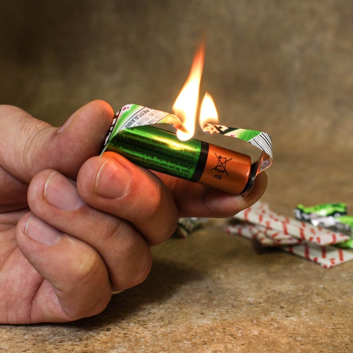 In the middle of a catastrophe, that pack of Juicy Fruit serves a far greater purpose than just staving off hunger or freshening your breath. Use the foil-backed wrapper to short circuit an AA battery and create a flame. First, tear the wrapper into an hourglass shape and touch the foil to the positive and negative battery terminals. The electrical current will briefly cause the paper wrapper to ignite. Use the flame to light a candle or tinder.