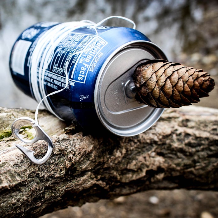 When resources run low, use a tin pop can to make what is colloquially known as a “hand-reel hobo kit”—essentially an improvised fishing pole. Use a knife or pliers to pry off the tab on the top, and break apart one of the small rings into a barbed fishing hook. Tie it to a piece of dental floss or any other string-like material, and wind the rest around the can. Use the makeshift rod to catch perch or other small fish. You can even store worms for bait inside the empty can.