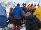 Ueli Steck (lower left) on the ground at Everest's Camp 2, after being attacked by Tashi Sherpa. Simone Moro can be seen fleeing camp (upper left, orange jacket).