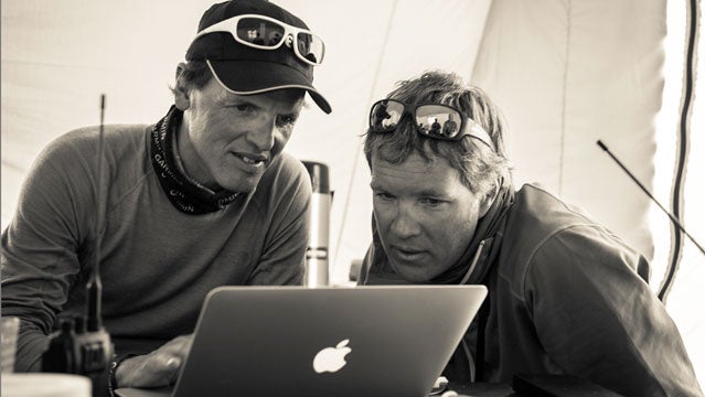 Simone Moro and Jake Norton go over the photos that David Breashears shot from a helicopter, hovering at above 27,000 feet, this morning.