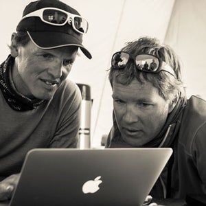 Simone Moro and Jake Norton go over the photos that David Breashears shot from a helicopter, hovering at above 27,000 feet, this morning.