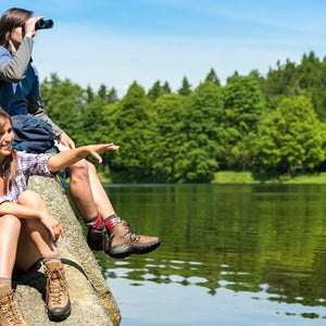Teenage hikers birdwatching at lake
