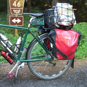 You'd be surprised how much gear you can comfortably get on a bike, but get a trailer if the extra onboard weight is tough to handle.