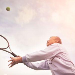 An older athlete hitting the ball.