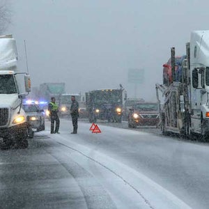 Rockdale County police officers assist a stranded tractor trailer truck on I-20 West near Conyers, Ga. on Tuesday, Jan. 28, 2014.