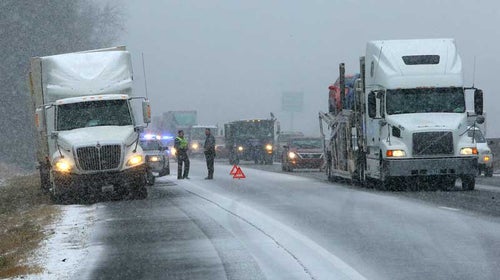 Rockdale County police officers assist a stranded tractor trailer truck on I-20 West near Conyers, Ga. on Tuesday, Jan. 28, 2014.