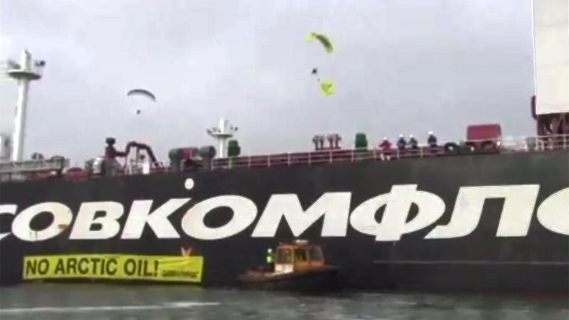 Greenpeace paragliders descend upon the Gazprom oil tanker Mikhael Ulyanov, named for a popular Russian actor.