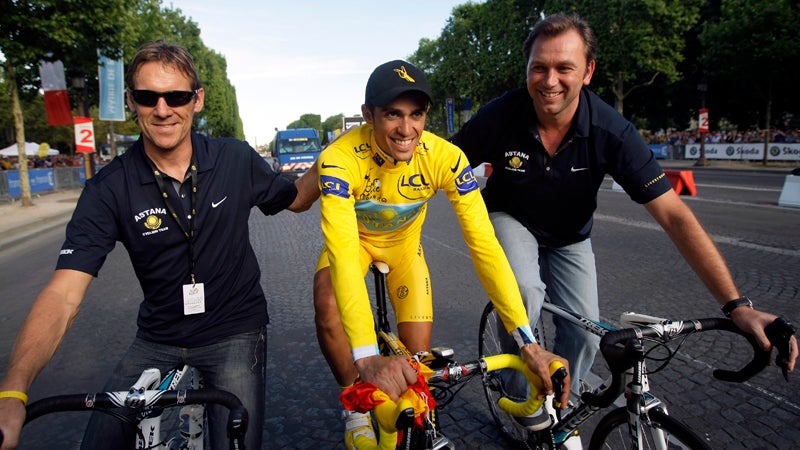 Tour de France winner Alberto Contador of Spain, wearing the overall leader's yellow jersey, center, rides with Astana sports directors Johan Bruyneel of Belgium, right, and  Dirk Demol of Belgium, after winning his second Tour de France cycling race, on the Champs Elysees avenue after the 21st stage of the Tour de France cycling race over 164 kilometers (101.9 miles) with start in Montereau-Fault-Yonne and finish in Paris, France, Sunday July 26, 2009. (AP Photo/Bas Czerwinski)