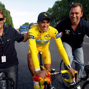 Tour de France winner Alberto Contador of Spain, wearing the overall leader's yellow jersey, center, rides with Astana sports directors Johan Bruyneel of Belgium, right, and  Dirk Demol of Belgium, after winning his second Tour de France cycling race, on the Champs Elysees avenue after the 21st stage of the Tour de France cycling race over 164 kilometers (101.9 miles) with start in Montereau-Fault-Yonne and finish in Paris, France, Sunday July 26, 2009. (AP Photo/Bas Czerwinski)