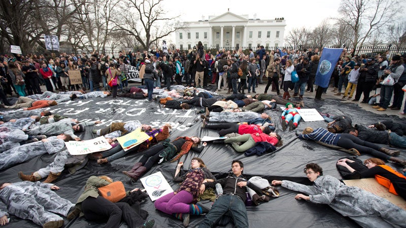 Demonstrators lie down along Pennsylvania Avenue in front of the White House during a protest against the proposed Keystone XL oil pipeline, Sunday, March 2, 2014. The protestors say the pipeline would contribute to global warming.