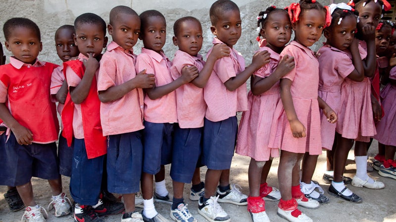 Children line up in front of their classroom before class at Church of God of Savanne Tapion School.