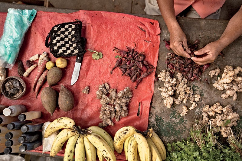 A woman sells natural medicines and food in a market in Cotamana.