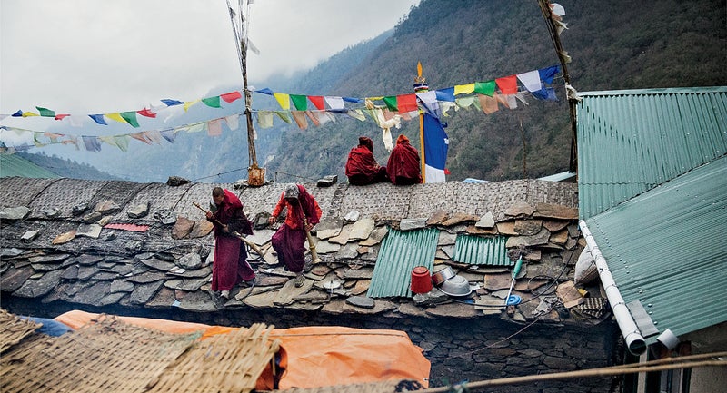 Monks sounding ceremonial horns on the roof of Ang Tshering's house in Thamo.