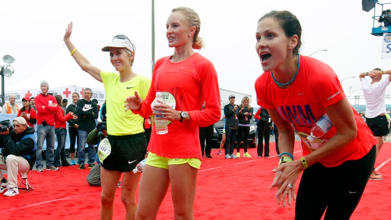 Joan Benoit Samuelson, Shalane Flanagan, and Kara Goucher cheer on other runners after completing the half marathon at the ninth annual Nike Women's Marathon in San Francisco.