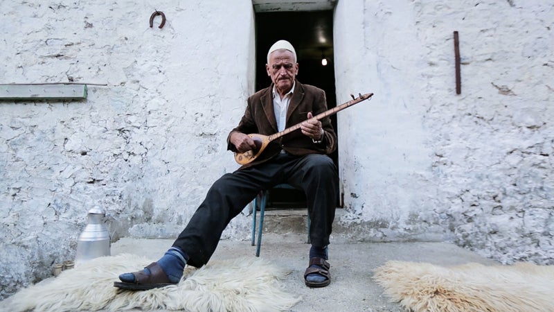 A villager in Thethi, Albania, strums a traditional, single-string lahuta. Albania is the only country along the Via Dinarica that was not a member of Yugoslavia.