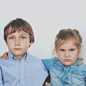 4-5 Years Anger Bonding Boy Brunette Hair Casual Clothing Caucasian Ethnicity Childhood Children  Only Friendship Front View Girl Hugging Indoors Innocence Leisure Lifestyles Looking At Camera Portrait Serious Sibling Simplicity Studio Shot Togetherness Two People Waist Up White Background