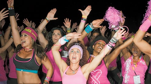 20-29 Years Anticipation Carefree Caucasian Ethnicity Cheerful Convention Center Dancing Enjoyment Exhilaration Femininity Fitness Front View Gesturing Hand Raised Happiness Indoors Leisure Lifestyles Medium  Group Of People Pink Pom Pom Portrait Railing Smiling Spectator Standing Tank Top Text Three Quarter Length Togetherness Vitality Waving Weekend Activities Western Script Woman Young Woman Youth Culture Zumba