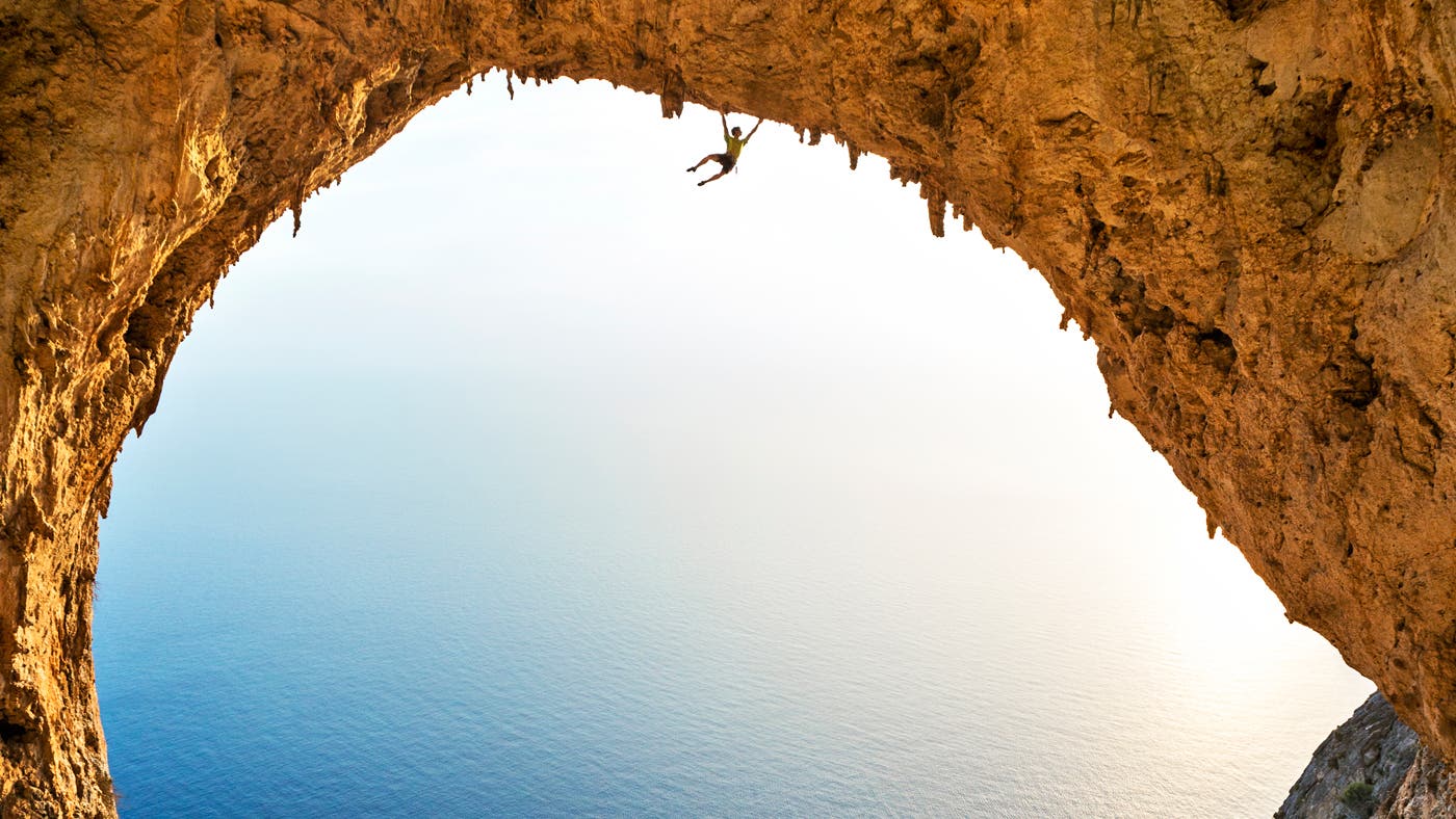 man hands off cliff face while climbing in telendos greece